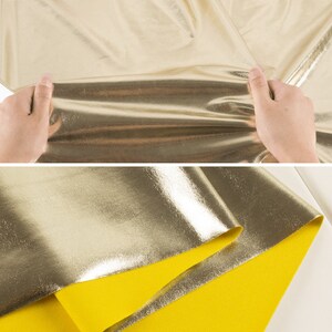 May include: Gold metallic fabric with a yellow backing. The fabric is folded in half and the metallic side is facing up.