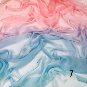 K&ouml;nnte beinhalten: Ein durchsichtiger Stoff mit einem Farbverlauf von Rosa, Lila und Blau. Der Stoff ist drapiert und gefaltet, wodurch ein weicher und flie&szlig;ender Look entsteht.