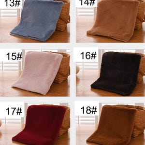 Peut inclure: Six &eacute;chantillons de tissu en fausse fourrure de diff&eacute;rentes couleurs, num&eacute;rot&eacute;s de 13# &agrave; 18#. Les &eacute;chantillons sont pr&eacute;sent&eacute;s sur une surface en bois avec un panier en osier derri&egrave;re chacun d'eux.