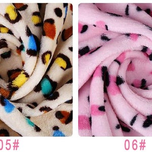 May include: Two fabric swatches with a leopard print pattern. The first swatch is a cream color with brown, yellow, blue, and green spots. The second swatch is pink with black spots. The swatches are labeled "05#" and "06#" respectively.