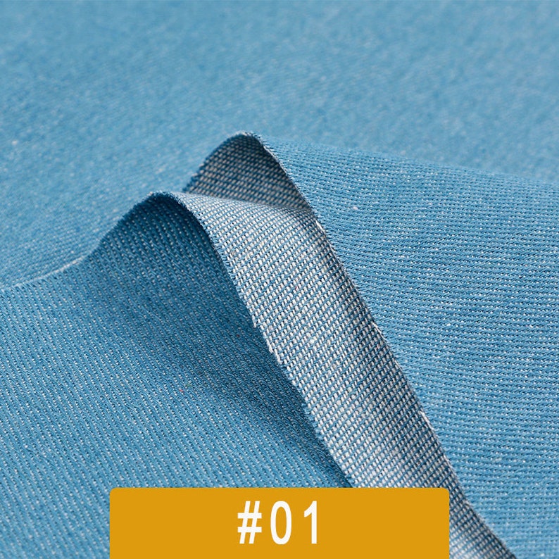 May include: Close-up of a blue fabric with a subtle texture. The fabric is folded over, revealing a lighter blue underside. The image is labeled with the number "#01".