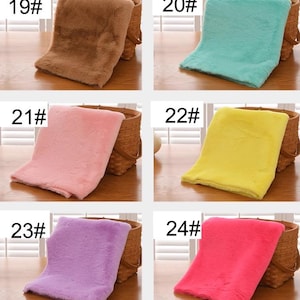 Peut inclure: Six &eacute;chantillons de tissu en fausse fourrure de diff&eacute;rentes couleurs, chacun pr&eacute;sent&eacute; sur un panier tiss&eacute;. Les &eacute;chantillons sont num&eacute;rot&eacute;s de 19 &agrave; 24.