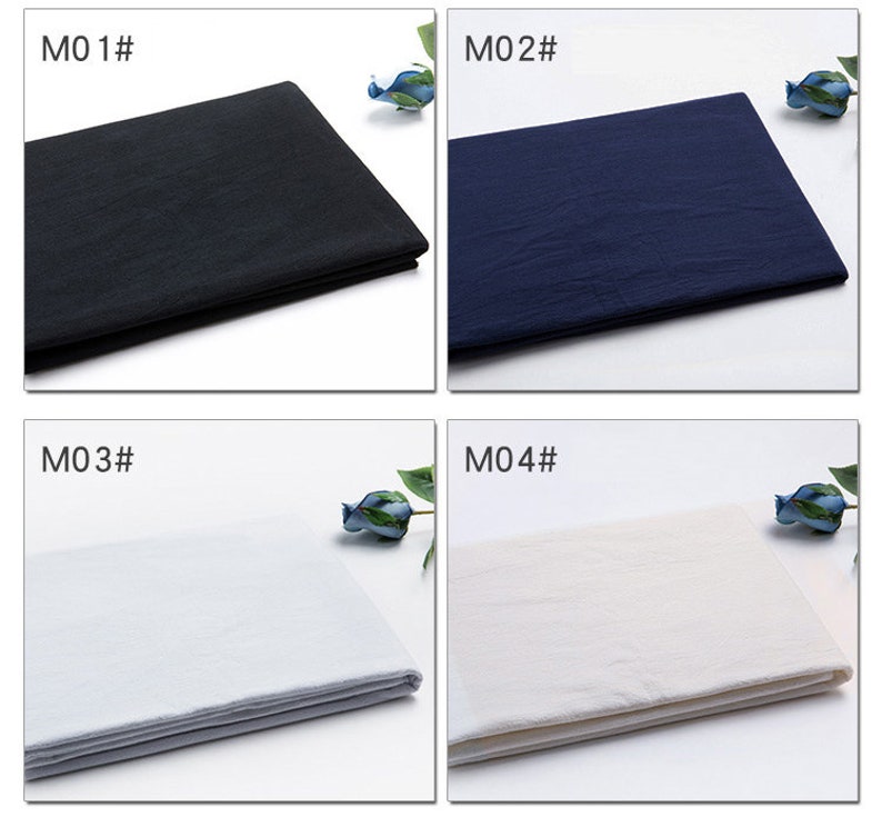 May include: Four fabric swatches in different colours: black, navy blue, white, and off-white. Each swatch is folded in half and laid flat on a white surface. The swatches are labelled with the numbers M01, M02, M03, and M04.