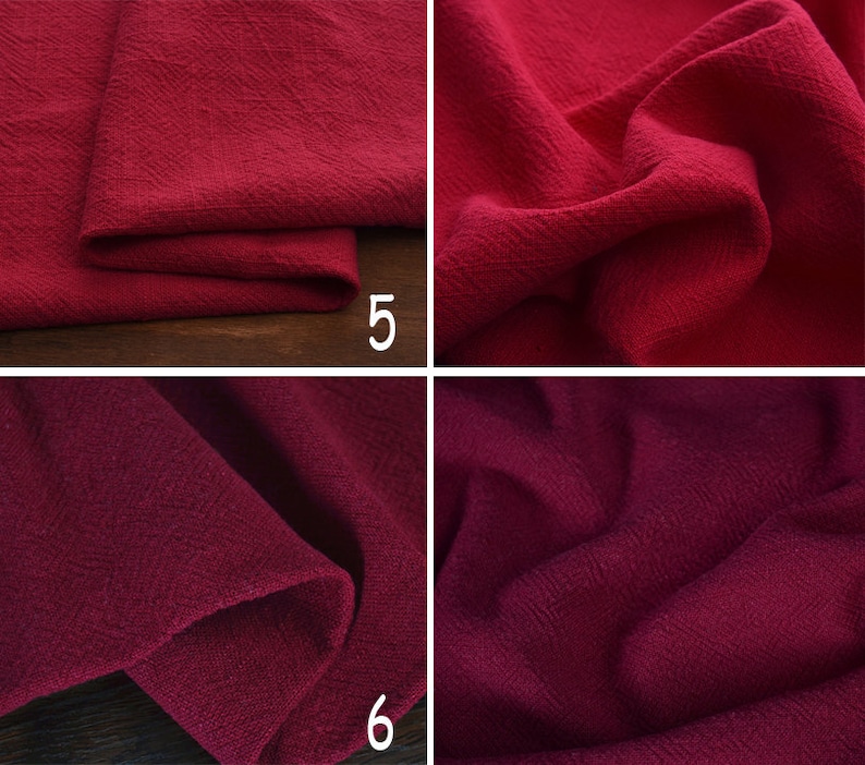 May include: Close-up of a deep red fabric with a textured weave. The fabric is folded and draped, showing the texture and colour.