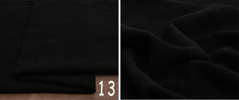 May include: Black fabric with a textured surface. The fabric is folded and the number 13 is visible in the bottom right corner.