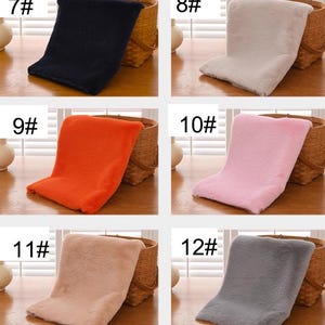 Peut inclure: Six &eacute;chantillons de tissu en fausse fourrure de diff&eacute;rentes couleurs dispos&eacute;s sur une surface en bois. Les &eacute;chantillons sont num&eacute;rot&eacute;s de 7 &agrave; 12. Les couleurs sont bleu marine, gris clair, orange, rose, brun clair et gris.