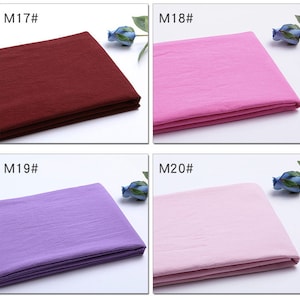 May include: Four fabric swatches in different colours: burgundy, pink, lavender, and light pink. Each swatch is folded in thirds and has a label with a number and the letter "M" in front of it. The labels read "M17", "M18", "M19", and "M20".