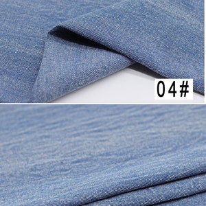 Puede incluir: Primer plano de una tela vaquera azul claro con una textura sutil. La tela est&aacute; doblada por la mitad, mostrando el interior y el exterior del material. El texto "04#" es visible en la imagen.
