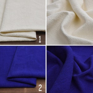 May include: Two fabric swatches, one off-white and one royal blue. Both fabrics have a textured, woven appearance.