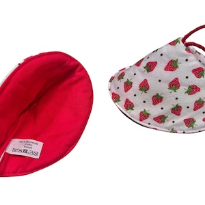 Könnte beinhalten: Zwei Stoff-Topflappen. Einer ist innen rot und außen weiß mit Erdbeermuster. Der andere ist innen rot. Das Erdbeermuster umfasst rote Erdbeeren mit grünen Blättern und schwarzen Punkten auf weißem Hintergrund.