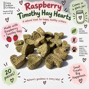 May include: A collection of heart-shaped treats made from compressed green hay. The text on the image reads: Cozy Indoor Critters, Raspberry Timothy Hay Hearts, A natural treat for happy, healthy critters, Made with Raspberry + Timothy Hay, 20 pieces!, Comes in a glass jar!, 100% NATURAL INGREDIENTS, OAT FREE, PERFECT FOR RABBITS, HAMSTERS, GUINEA PIGS & OTHER SMALL ANIMALS, Small Treats. Big Happiness., Nature's goodness in every bite!