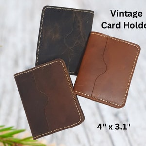 May include: Three vintage leather card holders in brown, dark brown, and black. Each holder has a stitched edge and measures 4 inches by 3.1 inches.