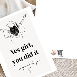 Peut inclure: Carte de f&eacute;licitations de fin d'&eacute;tudes avec une illustration en noir et blanc d'une dipl&ocirc;m&eacute;e les bras lev&eacute;s. Le texte dit "Yes girl, you did it, so proud of you" avec un c&oelig;ur. Fond neutre.