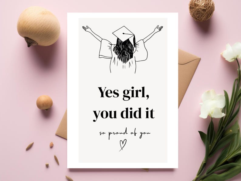 Peut inclure: Carte de f&eacute;licitations de fin d'&eacute;tudes avec une illustration en noir et blanc d'une dipl&ocirc;m&eacute;e les bras lev&eacute;s. Le texte dit : &laquo; Yes girl, you did it, so proud of you &raquo; avec un c&oelig;ur. Sur fond rose.