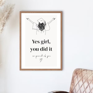 Peut inclure: Une affiche encadr&eacute;e avec une illustration minimaliste d'une dipl&ocirc;m&eacute;e en chapeau et robe, les bras lev&eacute;s. L'affiche porte l'inscription "Yes girl, you did it, so proud of you" dans une police &eacute;l&eacute;gante. Le cadre est marron chaud.