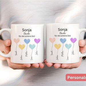 May include: Two white ceramic mugs with handles, each decorated with heart-shaped balloons in pastel shades. The mugs are printed with the name "Sonja" and the phrase "Danke f&uuml;r die sch&ouml;ne Zeit", plus names beneath the balloons.