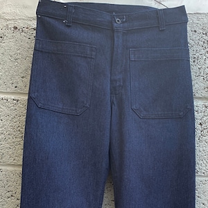 May include: A pair of dark blue denim bell bottom pants with large patch pockets on the front.