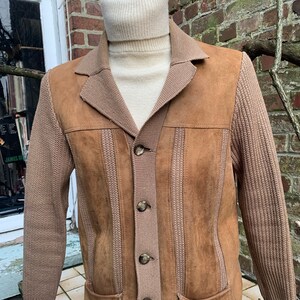 May include: A brown suede and knit jacket with a button closure. The jacket has a knitted collar and sleeves, and a suede front and back.