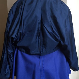 May include: A blue blazer with a black collar and a blue skirt. The blazer has a label that reads "Made in Italy" and "Wrangler Fashion Italy".