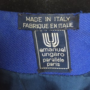 May include: A blue label with white text that reads "Made in Italy Fabrique en Italie" and a smaller blue label with white text that reads "emanuel ungaro parallele paris".