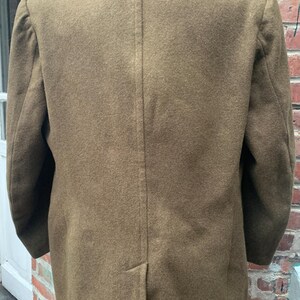 May include: A brown wool jacket with a double-breasted closure and a single back vent.