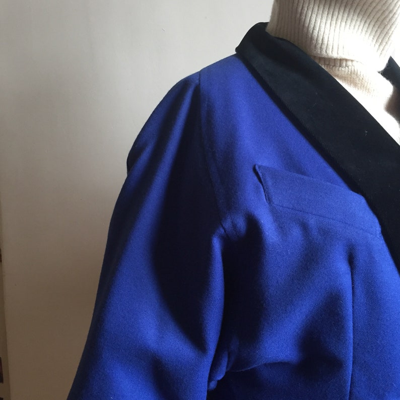 May include: A blue blazer with a black velvet collar. The blazer has a pocket on the left side.