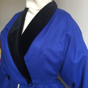 May include: A royal blue blazer with a black velvet collar. The blazer has a double breasted closure and long sleeves.