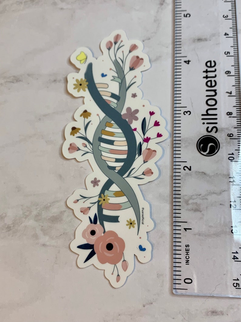 May include: A sticker featuring a stylised DNA double helix intertwined with floral elements. The DNA is depicted in shades of blue, grey, and yellow, with pink, white, and yellow flowers surrounding it. The sticker is approximately 5 cm tall.