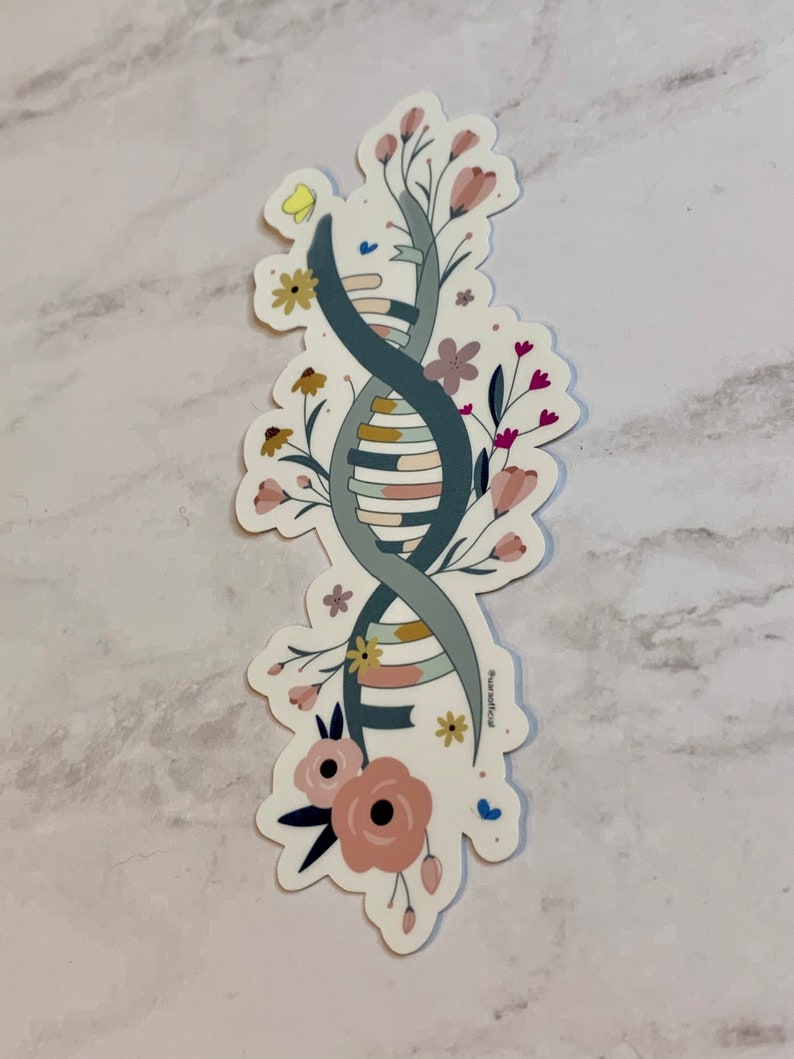 May include: A sticker featuring a stylised DNA double helix intertwined with colourful flowers. The DNA is depicted in shades of blue and green, while the flowers are pink, yellow, and red. The sticker has a white background and the text "#surreallife" at the bottom.