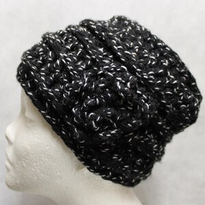 Könnte beinhalten: Schwarze und weiße Strickmütze mit strukturiertem Design.