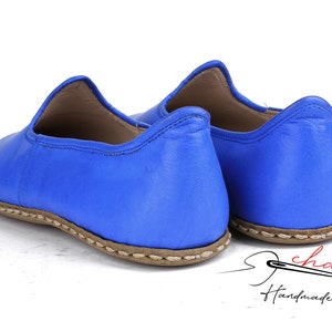 Pu&ograve; includere: Un paio di scarpe blu in pelle da indossare con suola cucita marrone. Le scarpe sono fatte a mano e hanno un design semplice ed elegante.