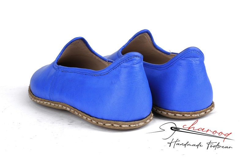 Pu&ograve; includere: Un paio di scarpe blu in pelle da indossare con suola cucita marrone. Le scarpe sono fatte a mano e hanno un design semplice ed elegante.