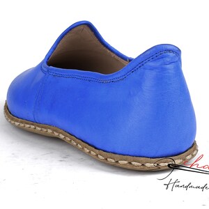 Pu&ograve; includere: Un paio di scarpe blu in pelle da indossare con suola cucita marrone. Le scarpe sono fatte a mano e hanno un design semplice ed elegante.