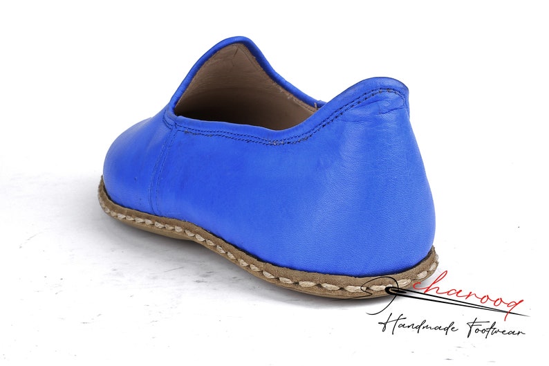 Pu&ograve; includere: Un paio di scarpe blu in pelle da indossare con suola cucita marrone. Le scarpe sono fatte a mano e hanno un design semplice ed elegante.