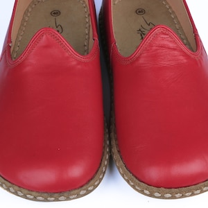 Puede incluir: Primer plano de dos zapatos rojos de cuero. Los zapatos tienen una puntera redondeada y una suela cosida de color marr&oacute;n claro. El interior es de color marr&oacute;n claro. Los zapatos son de la talla 40.