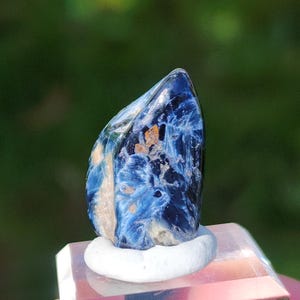 K&ouml;nnte beinhalten: Ein blauer und wei&szlig;er Edelstein mit einem einzigartigen Muster. Der Edelstein befindet sich auf einem wei&szlig;en St&auml;nder.