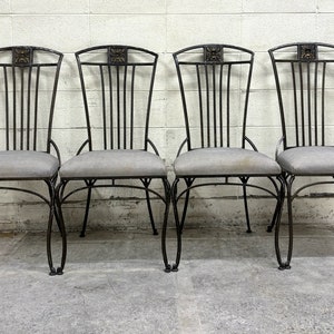 May include: Four black metal chairs with gray fabric seats. The chairs have a decorative design on the back.