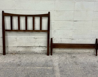 May include: A dark brown wooden headboard and footboard for a bed. The headboard has a curved top and vertical slats. The footboard is a simple rectangular shape.