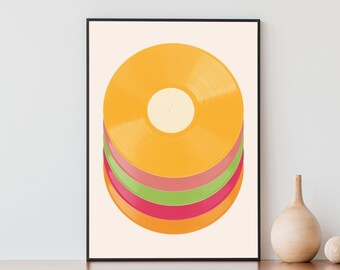 Könnte beinhalten: Gerahmter Kunstdruck mit einem Stapel farbenfroher Schallplatten. Die oberste Schallplatte ist leuchtend gelb-orange, darunter liegen rosa, grüne und rote Platten. Das Kunstwerk wird vor einem cremefarbenen Hintergrund präsentiert.