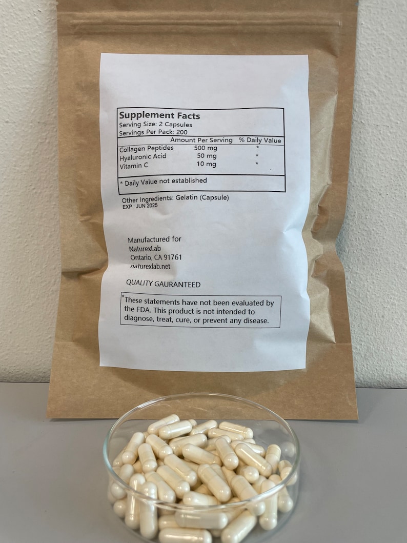 May include: A brown paper bag with a white label containing supplement facts for a product with 500 mg of collagen peptides, 50 mg of hyaluronic acid, and 10 mg of vitamin C. The label also states that the product is manufactured for NaturexLab in Ontario, CA 91761. A clear glass dish filled with white capsules is in the foreground.
