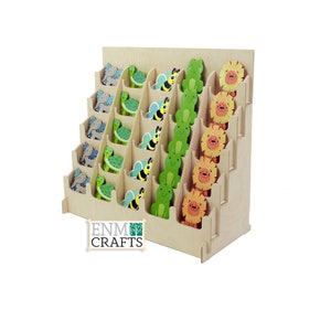 May include: Wooden display stand with shelves for showcasing small wooden animal figurines. The stand is made of natural wood and has a light brown color. The figurines are painted in bright colors and feature a variety of animals, including elephants, turtles, bees, frogs, and lions. The stand has the text "ENM CRAFTS" printed on the front.