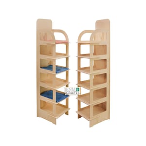May include: Two wooden display shelves with five shelves each. The shelves are made of light wood and have a rounded edge. The shelves are empty, but there are some blue and pink cloths on the shelves. The shelves are labelled "ENM CRAFTS".