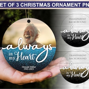 May include: Set of 3 Christmas ornaments with the text "always in my Heart". One ornament features a photo of a smiling man. The other two ornaments have a glitter design with the same text. The ornaments are round with a gold string.