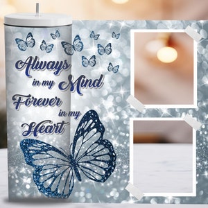May include: A silver glitter tumbler with a blue butterfly and the text "Always in my Mind Forever in my Heart". The tumbler has two photo frames with white borders.