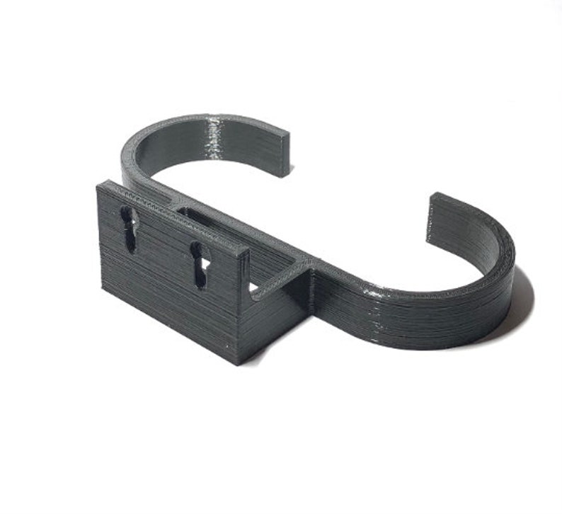 May include: A dark gray, 3D-printed wall hook. The hook has a rectangular base with two keyhole-shaped mounting holes and a curved, open hook design. The hook is designed to hold items and is made of a durable material.