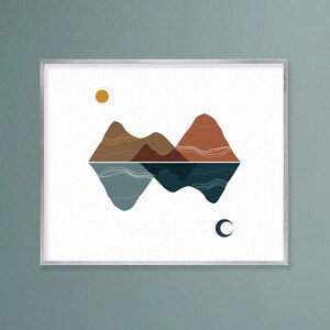 May include: A framed print with a minimalist design of mountains and water, featuring a yellow sun and a crescent moon.