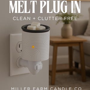 Peut inclure: Un diffuseur de parfum blanc &agrave; brancher, avec un bord noir, branch&eacute; dans une prise murale. Le diffuseur contient des cubes de cire. Le texte sur l'image dit "KEEP THE SCENT GOING WITH A MELT PLUG IN CLEAN + CLUTTER FREE".