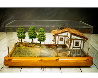 A diorama of a medieval tavern. A traveler heads to the tavern to stay the night.