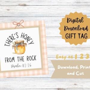 Peut inclure: Une étiquette cadeau à télécharger numériquement avec une illustration à l'aquarelle d'un pot de miel. L'étiquette indique "There's Honey From The Rock Psalm 81:16". Le texte supplémentaire comprend "Digital Download GIFT TAG" et "Easy as 1 2 3 Download, Print, and Cut".