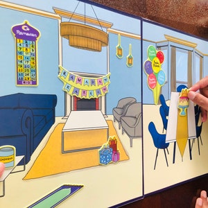 Pu&ograve; includere: Un pannello di feltro colorato a tema Ramadan. Il pannello presenta una scena di soggiorno con un divano, un tavolino da caff&egrave;, un camino e un calendario con i giorni del Ramadan. Ci sono anche decorazioni come palloncini, una torta e uno striscione che dice "Ramadan Kareem".